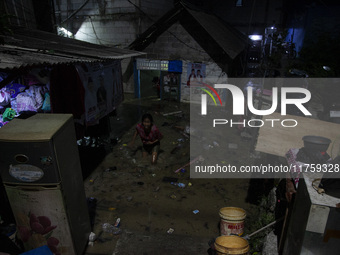 Residents on the riverbanks flee to higher ground when their settlements flood due to the overflow of the Cikeas River after heavy rain for...