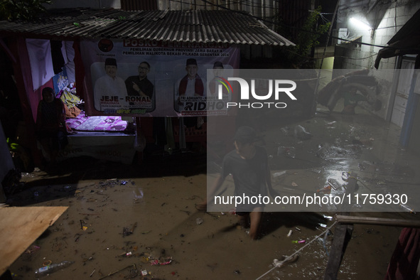 Residents on the riverbanks flee to higher ground when their settlements flood due to the overflow of the Cikeas River after heavy rain for...