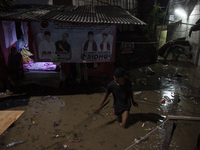 Residents on the riverbanks flee to higher ground when their settlements flood due to the overflow of the Cikeas River after heavy rain for...