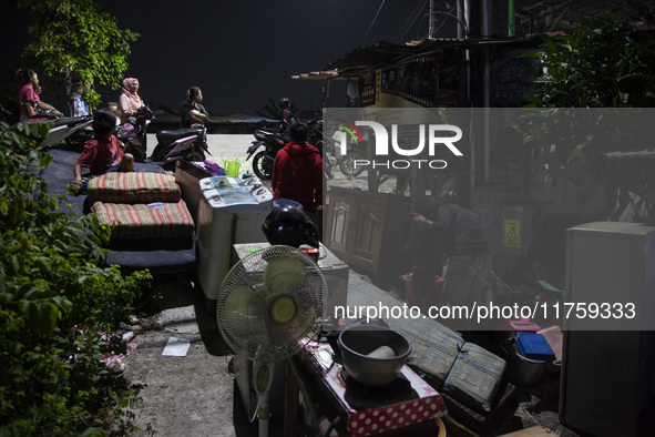 Residents on the riverbanks flee to higher ground when their settlements flood due to the overflow of the Cikeas River after heavy rain for...