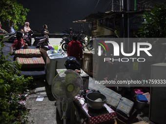 Residents on the riverbanks flee to higher ground when their settlements flood due to the overflow of the Cikeas River after heavy rain for...