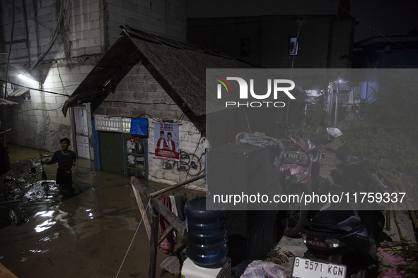 Residents on the riverbanks flee to higher ground when their settlements flood due to the overflow of the Cikeas River after heavy rain for...