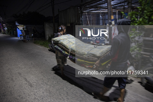 Residents on the riverbanks flee to higher ground when their settlements flood due to the overflow of the Cikeas River after heavy rain for...