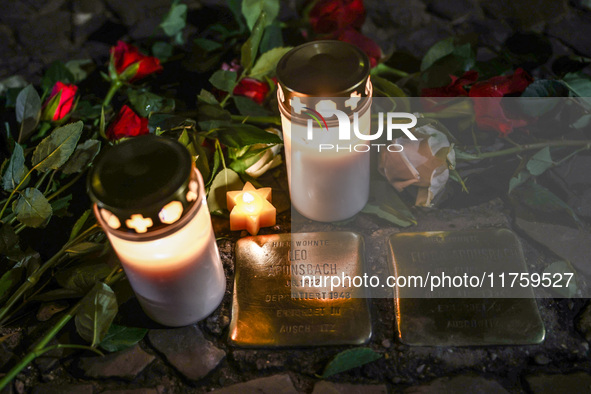 Candles and flowers are seen by stumbling stones (Stolpersteine) commemorating victims of Holocaust, during the 65th anniversary of Kristall...