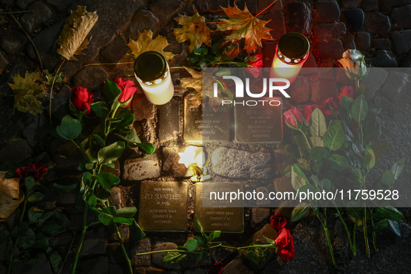 Candles and flowers are seen by stumbling stones (Stolpersteine) commemorating victims of Holocaust, during the 65th anniversary of Kristall...