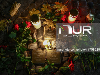 Candles and flowers are seen by stumbling stones (Stolpersteine) commemorating victims of Holocaust, during the 65th anniversary of Kristall...