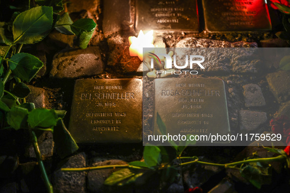 Candles and flowers are seen by stumbling stones (Stolpersteine) commemorating victims of Holocaust, during the 65th anniversary of Kristall...