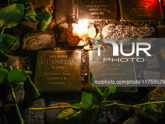 Candles and flowers are seen by stumbling stones (Stolpersteine) commemorating victims of Holocaust, during the 65th anniversary of Kristall...