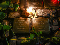 Candles and flowers are seen by stumbling stones (Stolpersteine) commemorating victims of Holocaust, during the 65th anniversary of Kristall...