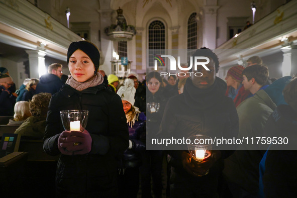 Young people carry candles in the Sophienkirche during the commemoration event of the 65th anniversary of the Night of Broken Glass (Kristal...