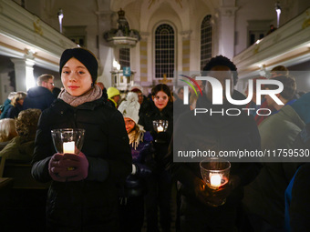 Young people carry candles in the Sophienkirche during the commemoration event of the 65th anniversary of the Night of Broken Glass (Kristal...