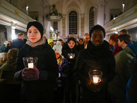 Young people carry candles in the Sophienkirche during the commemoration event of the 65th anniversary of the Night of Broken Glass (Kristal...