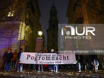 People stand in front of the Sophienkirche while attending a march commemorating the 65th anniversary of the Night of Broken Glass (Kristall...