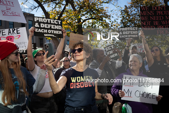 A woman takes selfies as hundreds demonstrate outside The Heritage Foundation for reproductive rights following the election of Donald Trump...