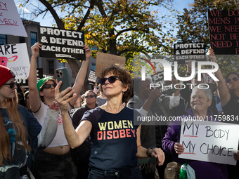 A woman takes selfies as hundreds demonstrate outside The Heritage Foundation for reproductive rights following the election of Donald Trump...