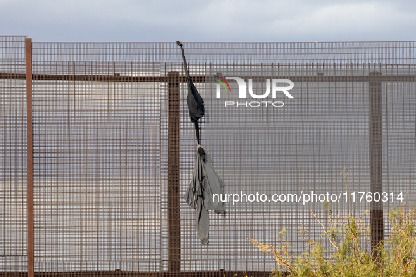 A sweatshirt hangs from the border wall between Ciudad Juarez, Mexico, and El Paso, United States, seemingly placed by migrants as support t...