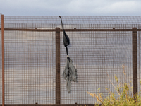 A sweatshirt hangs from the border wall between Ciudad Juarez, Mexico, and El Paso, United States, seemingly placed by migrants as support t...