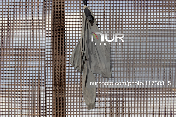 A sweatshirt hangs from the border wall between Ciudad Juarez, Mexico, and El Paso, United States, seemingly placed by migrants as support t...