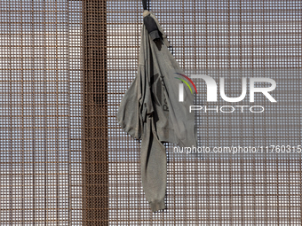 A sweatshirt hangs from the border wall between Ciudad Juarez, Mexico, and El Paso, United States, seemingly placed by migrants as support t...