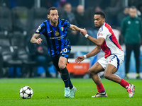 Hakan Calhanoglu of FC Internazionale and Jurrien Timber of Arsenal compete for the ball during the UEFA Champions League 2024/25 League Pha...