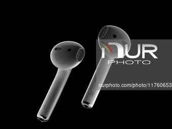 A studio still life of a pair of Apple AirPods on a black background highlights the modern and minimalist design of the AirPods, emphasizing...