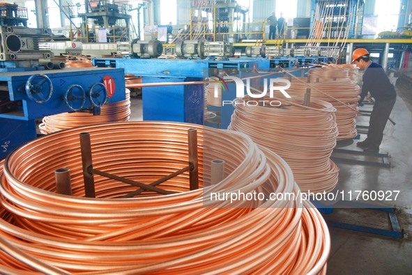 A worker of Yangfan Copper (Anhui) Co LTD works on a production line at the Yuexi County Economic Development Zone in Anqing, China, on Nove...