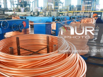 A worker of Yangfan Copper (Anhui) Co LTD works on a production line at the Yuexi County Economic Development Zone in Anqing, China, on Nove...