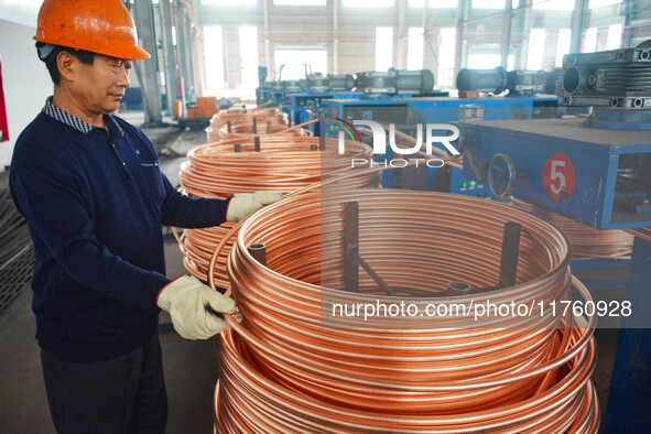 A worker of Yangfan Copper (Anhui) Co LTD works on a production line at the Yuexi County Economic Development Zone in Anqing, China, on Nove...