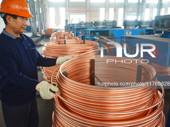 A worker of Yangfan Copper (Anhui) Co LTD works on a production line at the Yuexi County Economic Development Zone in Anqing, China, on Nove...