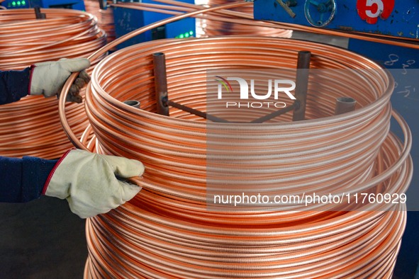 A worker of Yangfan Copper (Anhui) Co LTD works on a production line at the Yuexi County Economic Development Zone in Anqing, China, on Nove...