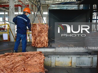 A worker of Yangfan Copper (Anhui) Co LTD works on a production line at the Yuexi County Economic Development Zone in Anqing, China, on Nove...