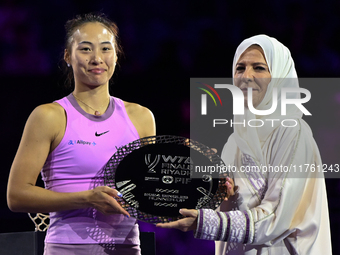 RIYADH, SAUDI ARABIA - NOVEMBER 09: Qinwen Zheng of China poses with the runner-up trophy alongside Saudi Tennis Federation president Arij M...