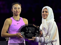 RIYADH, SAUDI ARABIA - NOVEMBER 09: Qinwen Zheng of China poses with the runner-up trophy alongside Saudi Tennis Federation president Arij M...