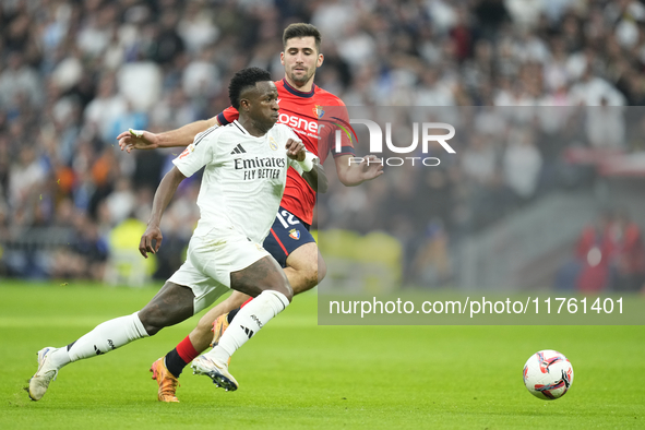 Vinicius Junior left winger of Real Madrid and Brazil and Jesus Areso right-back of Osasuna and Spain compete for the ball during the La Lig...