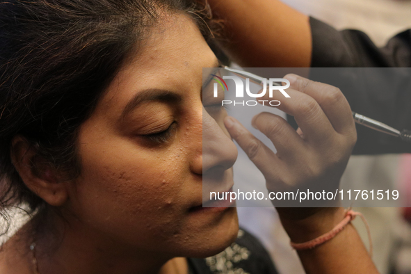 A model gets her makeup done before taking to the runway during a fashion show organized by Lions International in JW Marriott, Kolkata, Ind...