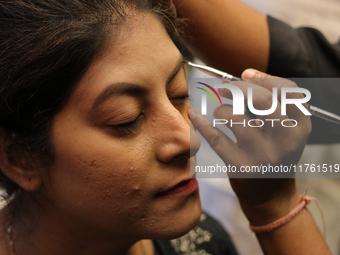 A model gets her makeup done before taking to the runway during a fashion show organized by Lions International in JW Marriott, Kolkata, Ind...