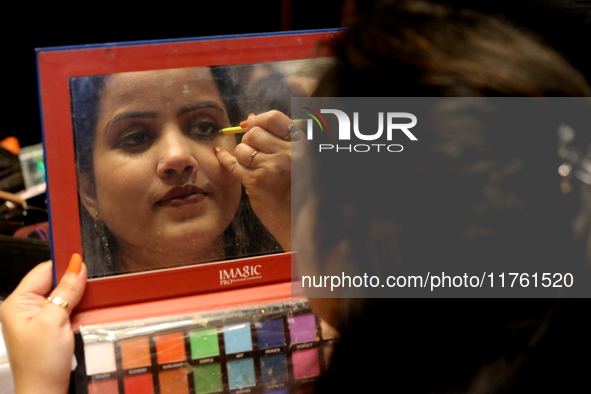 A model gets her makeup done before taking to the runway during a fashion show organized by Lions International in JW Marriott, Kolkata, Ind...