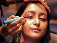 A model gets her makeup done before taking to the runway during a fashion show organized by Lions International in JW Marriott, Kolkata, Ind...