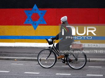 A mix of German and Israeli flags on the East Side Gallery in Berlin, Germany on November 8th, 2024. (