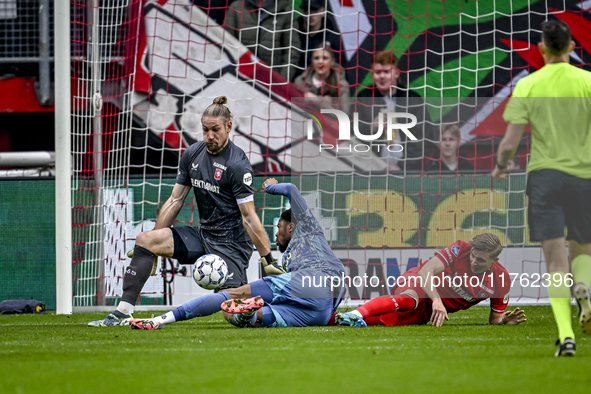 FC Twente goalkeeper Lars Unnerstall and AFC Ajax Amsterdam forward Chuba Akpom participate in the match between Twente and Ajax at the Grol...