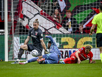 FC Twente goalkeeper Lars Unnerstall and AFC Ajax Amsterdam forward Chuba Akpom participate in the match between Twente and Ajax at the Grol...