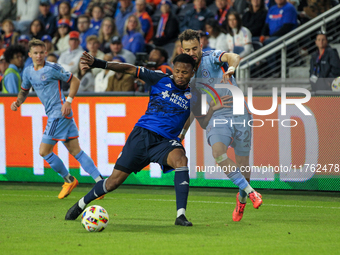 Cincinnati's Alvas Powell and New York's Kevin O'Toole compete for the ball during the 2024 MLS Cup Playoffs Round One match between FC Cinc...