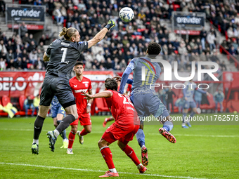 FC Twente goalkeeper Lars Unnerstall and AFC Ajax Amsterdam forward Chuba Akpom participate in the match between Twente and Ajax at the Grol...