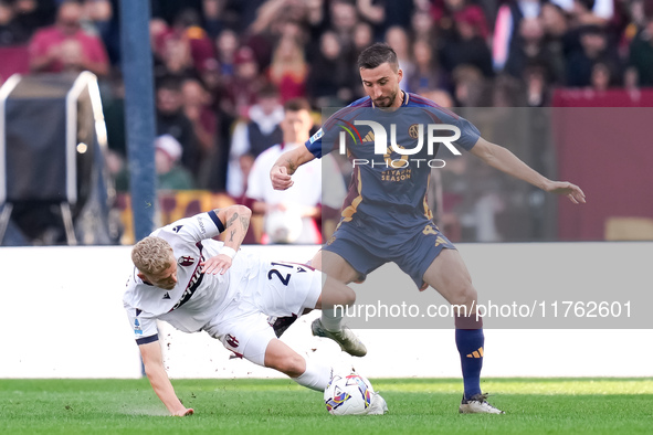 Jens Odgaard of Bologna FC and Bryan Cristante of AS Roma compete for the ball during the Serie A Enilive match between AS Roma and Bologna...