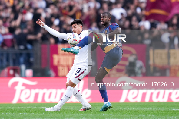 Evan Ndicka of AS Roma and Santiago Castro of Bologna FC compete for the ball during the Serie A Enilive match between AS Roma and Bologna F...