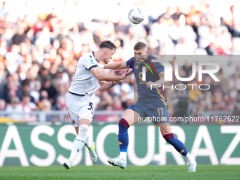 Artem Dovbyk of AS Roma and Sam Beukema of Bologna FC compete for the ball during the Serie A Enilive match between AS Roma and Bologna FC a...