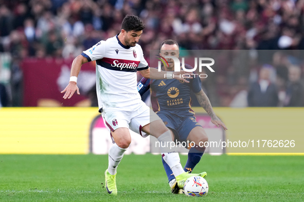 Riccardo Orsolini of Bologna FC and Angelino of AS Roma compete for the ball during the Serie A Enilive match between AS Roma and Bologna FC...