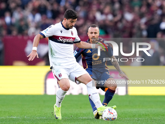 Riccardo Orsolini of Bologna FC and Angelino of AS Roma compete for the ball during the Serie A Enilive match between AS Roma and Bologna FC...