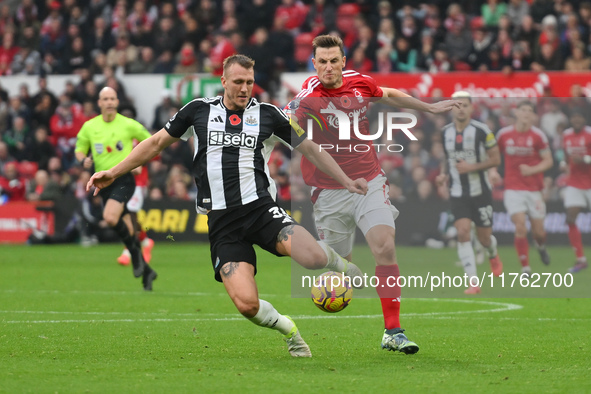 Chris Wood of Nottingham Forest puts pressure on Dan Burn of Newcastle United during the Premier League match between Nottingham Forest and...