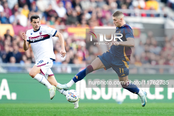 Remo Freuler of Bologna FC and Artem Dovbyk of AS Roma compete for the ball during the Serie A Enilive match between AS Roma and Bologna FC...